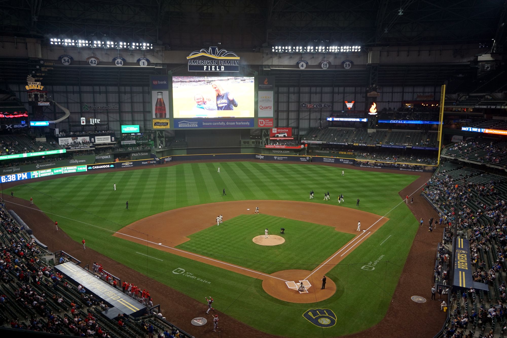 The seating bowl and field at American Family Field during a night game, with the videoboard lit beyond the outfield