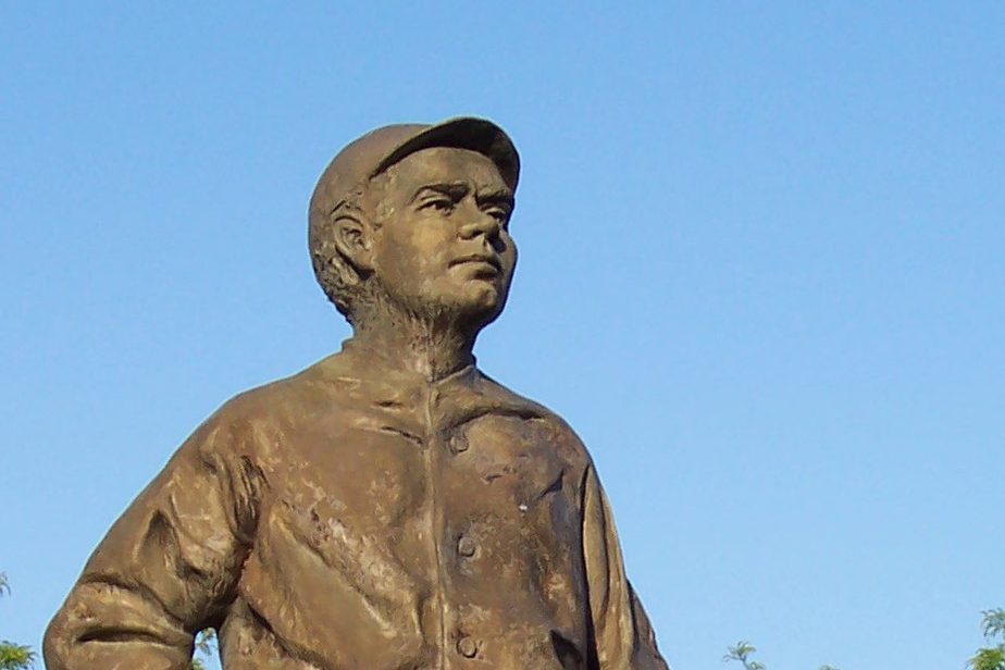 The head and shoulders of the Babe Ruth statue outside Camden Yards against a blue sky