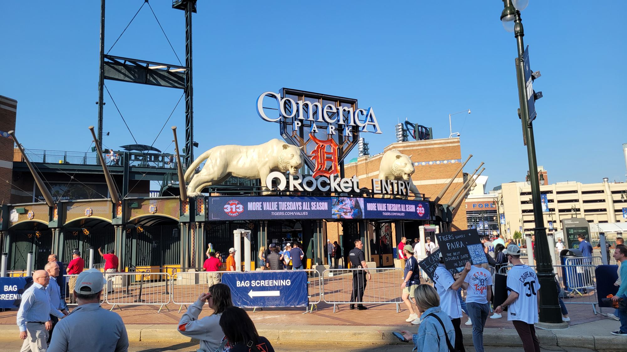 Fans outside the Comerica Park entrance, with a tiger statue perched above the gate