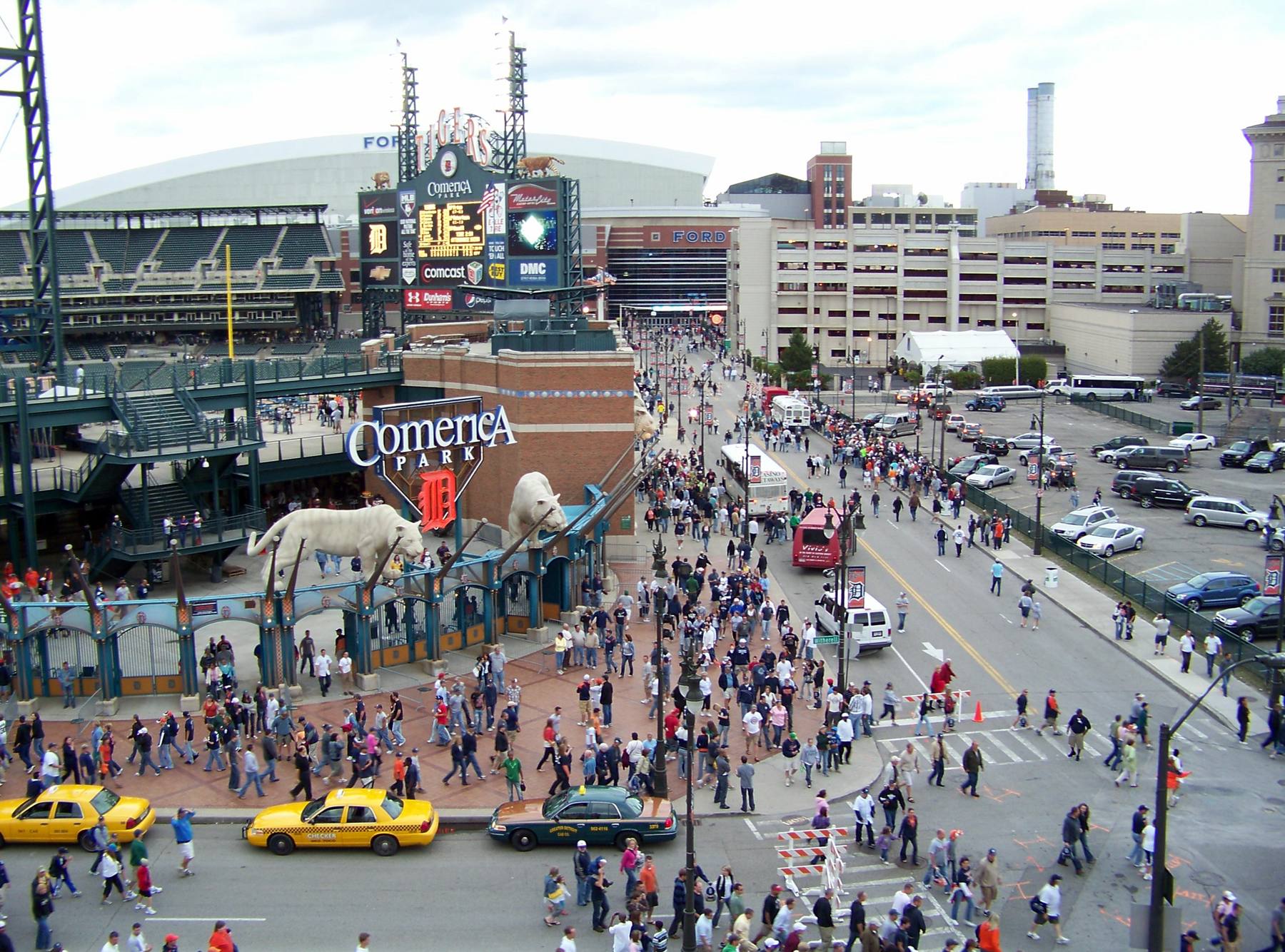 The crowd leaving Comerica Park after a game, taxis waiting along the street below the tiger statues