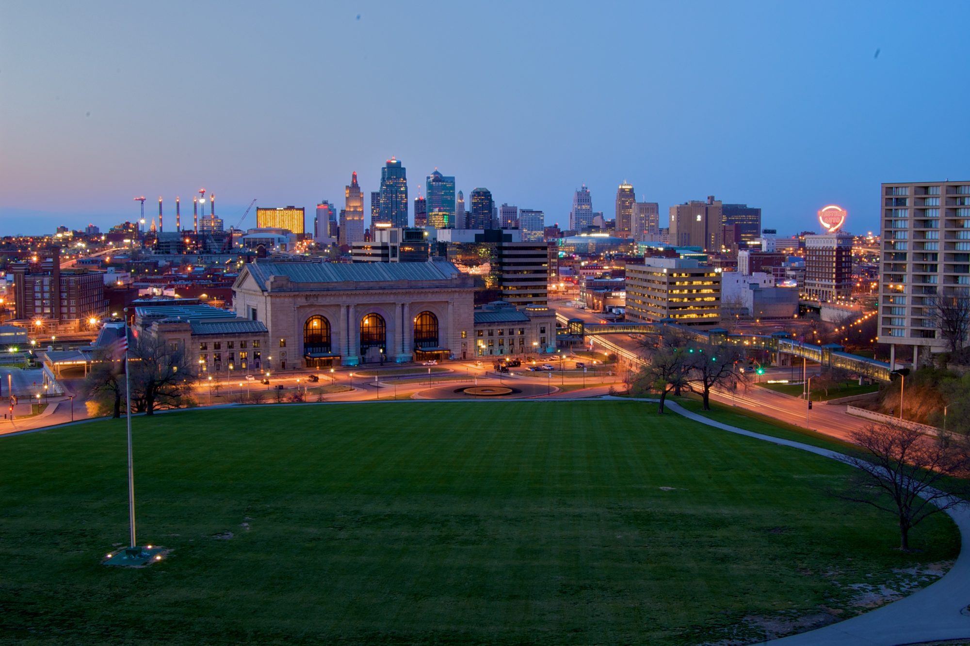 Kansas City's Union Station lit at dusk with the downtown skyline rising behind it