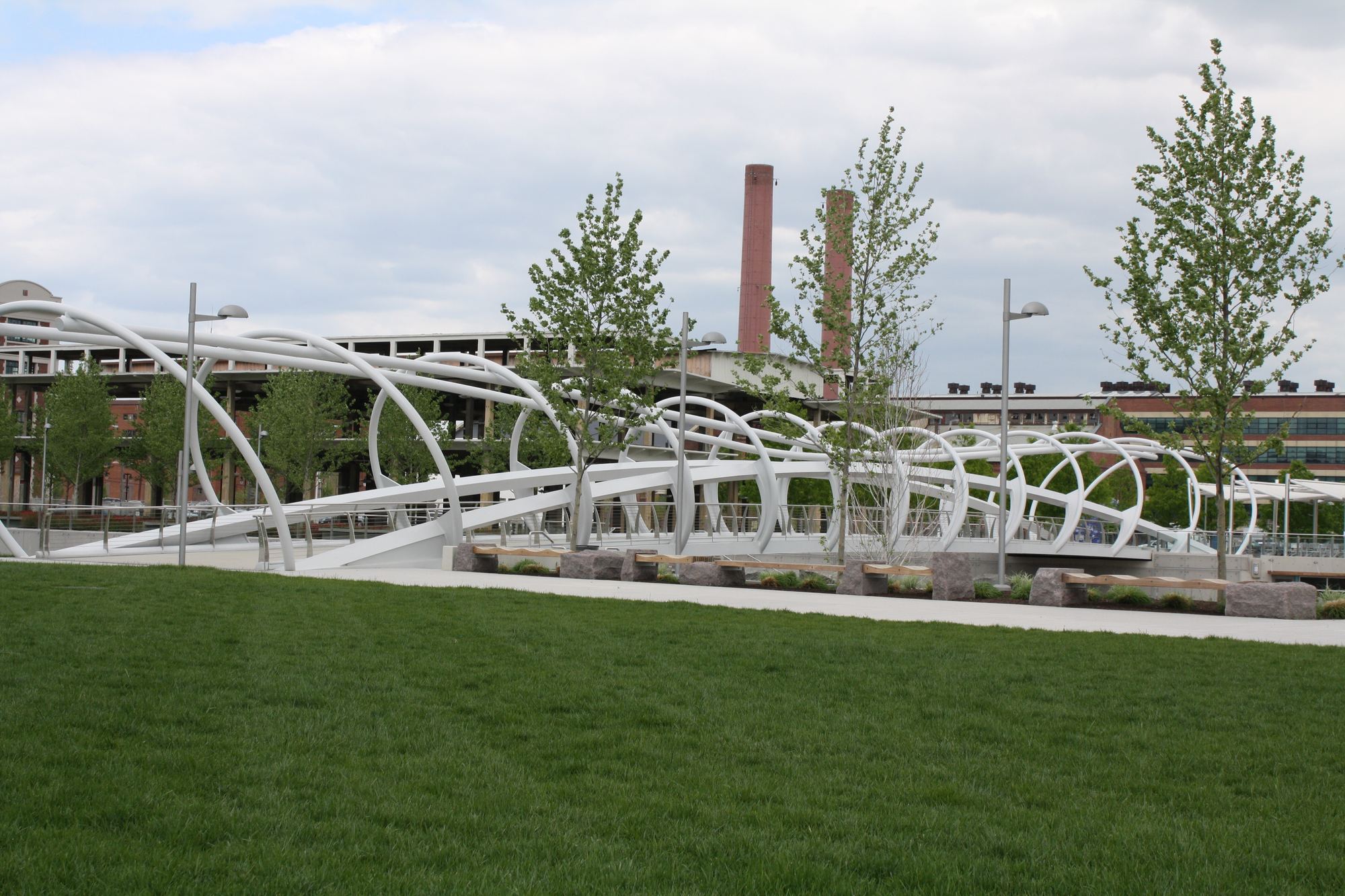 The white arched footbridge at Yards Park, with the brick warehouses and smokestacks of the old Navy Yard behind it