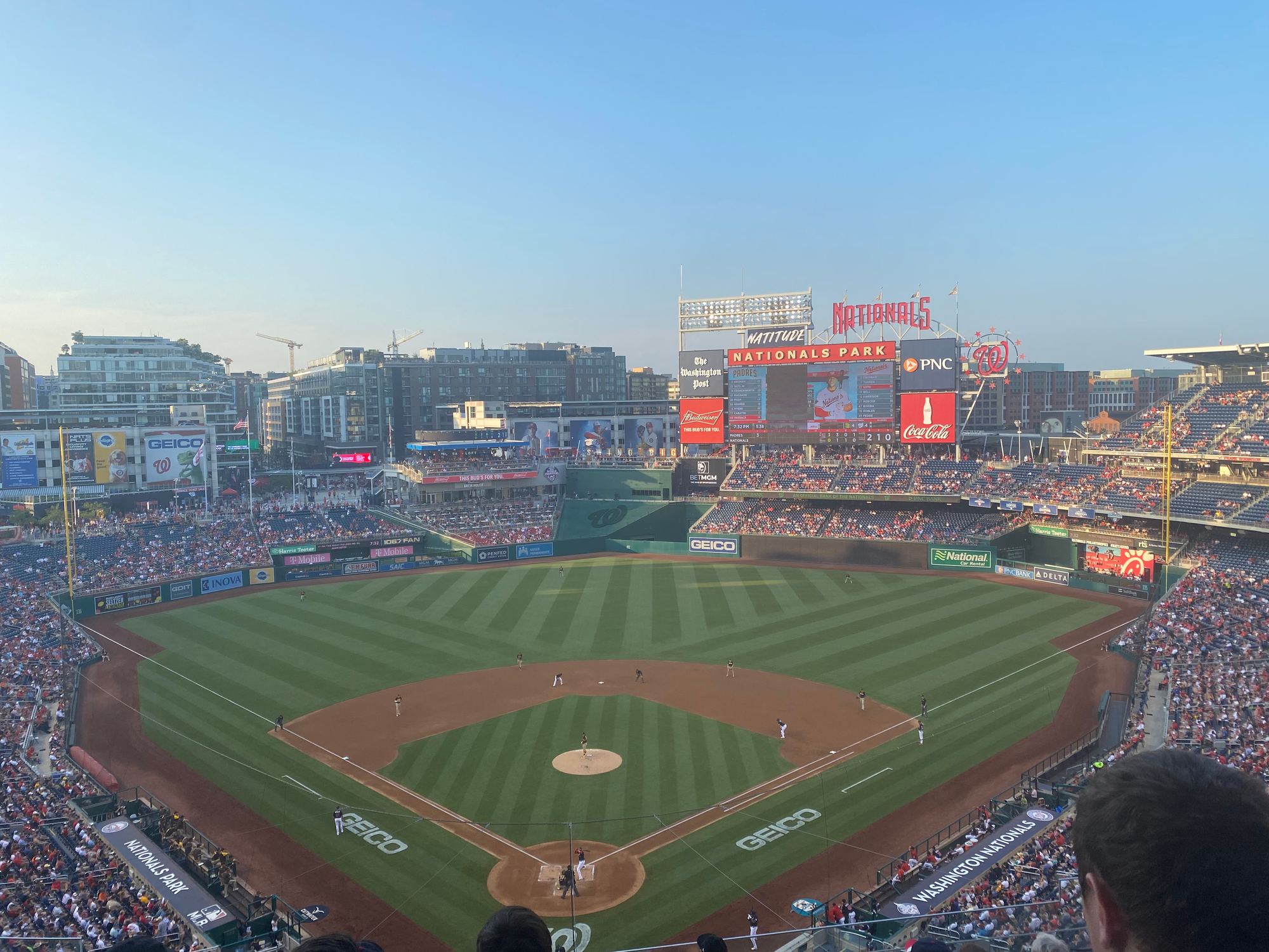 The field at Nationals Park from the upper deck behind home plate, with the Navy Yard buildings beyond the outfield