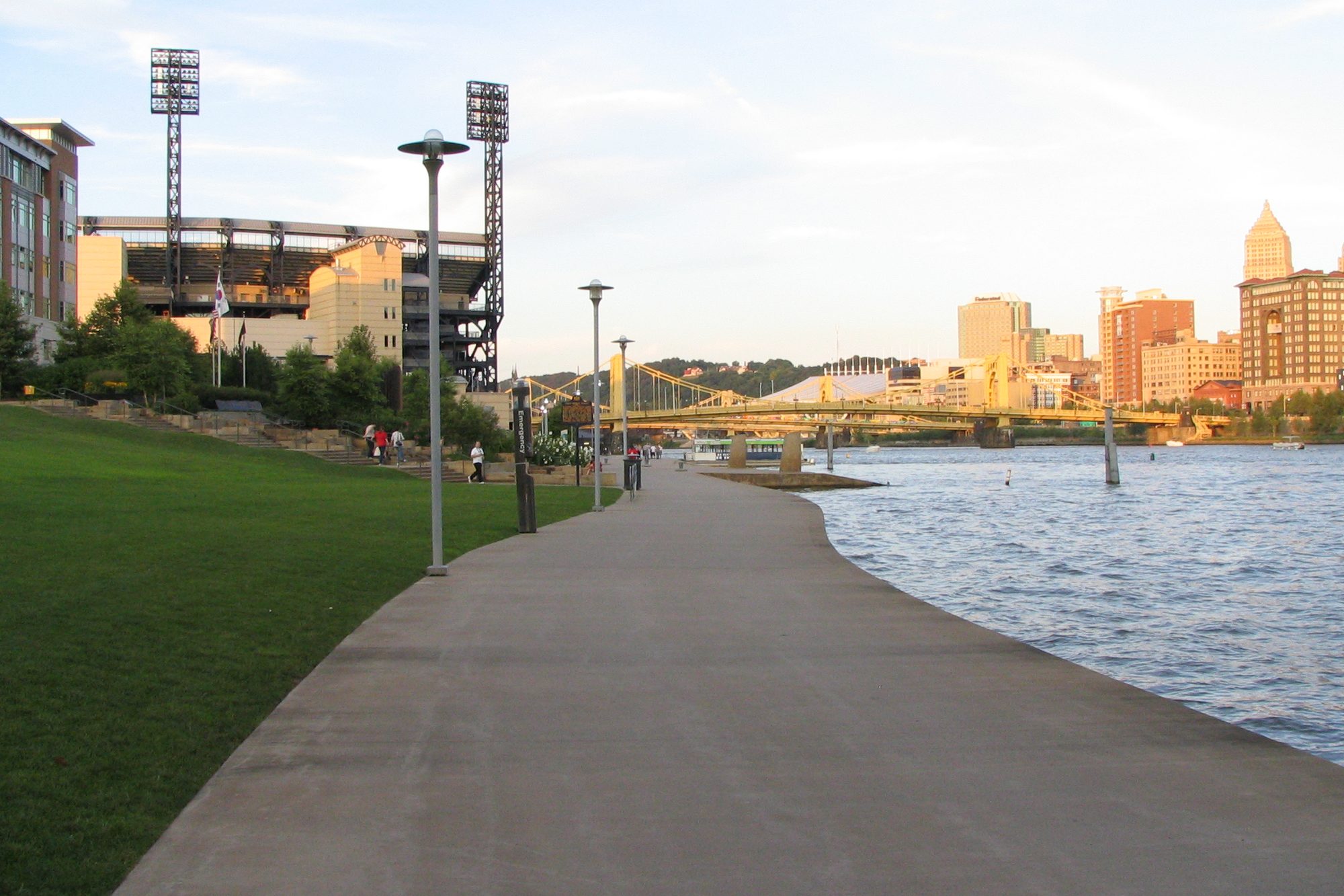 The North Shore riverfront walkway leading toward PNC Park, with the Pittsburgh skyline across the Allegheny River
