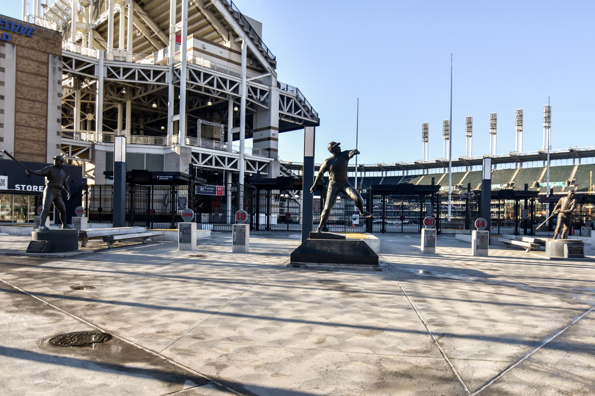 The Bob Feller statue on the gate plaza outside Progressive Field, the ballpark's exposed white steelwork rising behind it