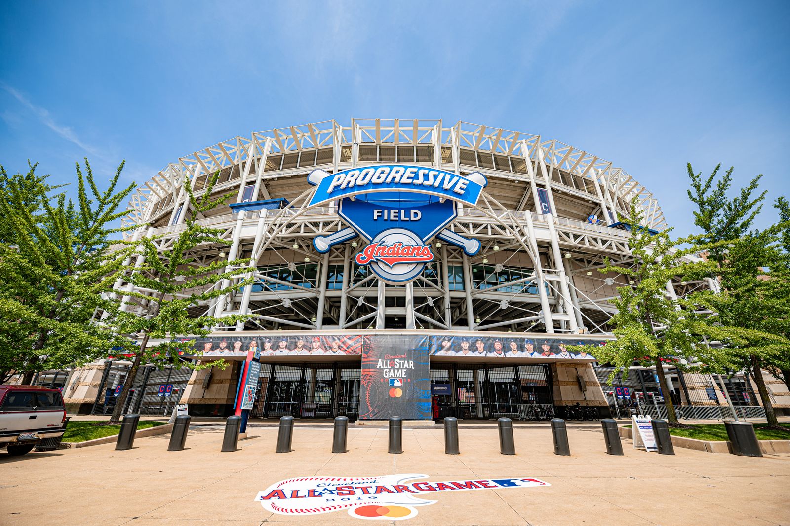 The main gate at Progressive Field under the large Progressive Field sign, the ballpark's steel frame and light towers overhead