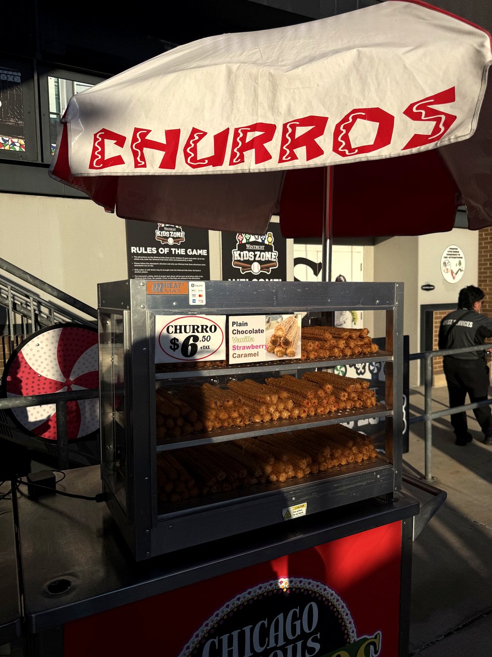 The churro cart on the main concourse at Rate Field, fresh churros under a red awning
