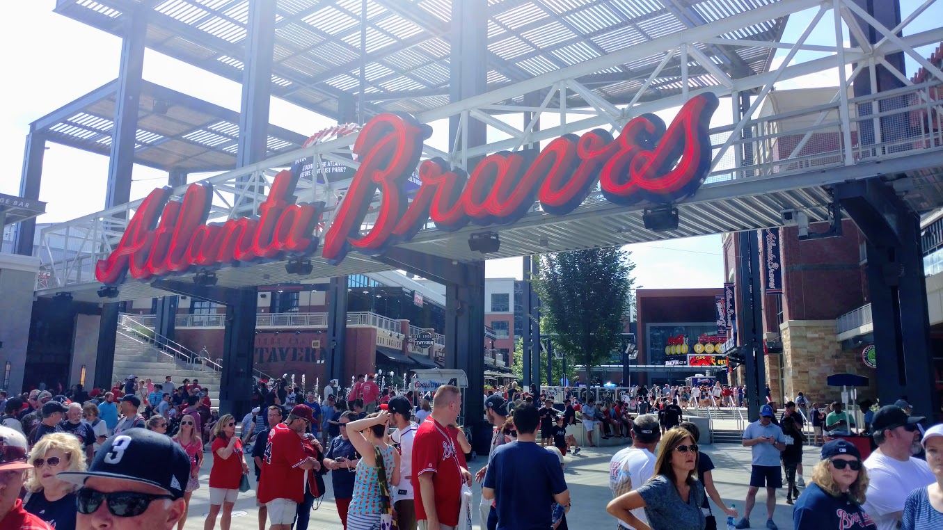 Fans walking under the Atlanta Braves sign on the plaza at The Battery Atlanta on a game day